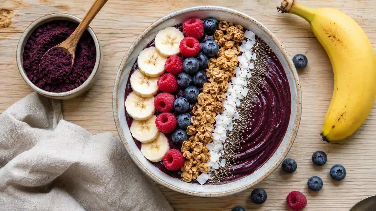 Violette Acai Bowl mit Granola, Banane, Beeren und Chiasamen
